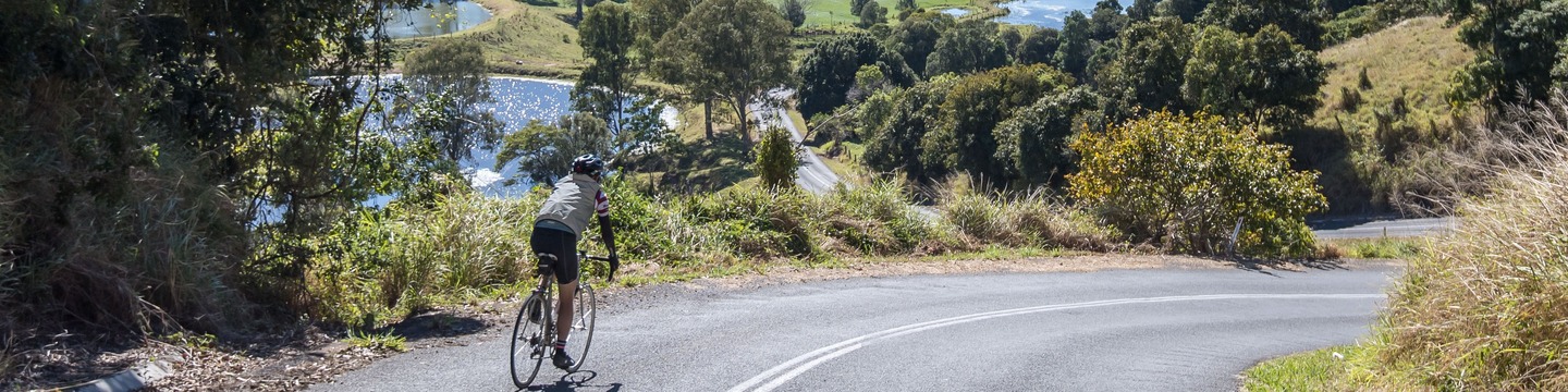 Man cycling on a road in the Noosa Hinterland