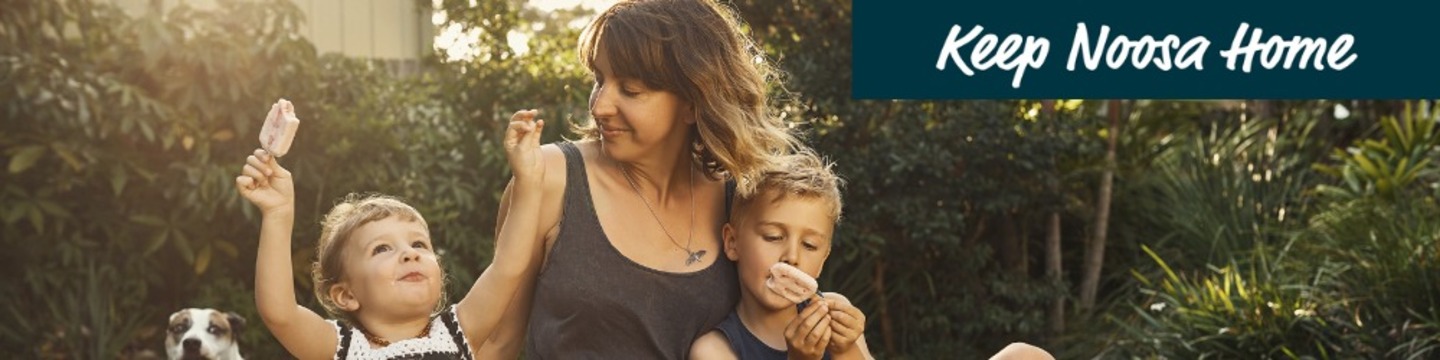 Woman and two small children sit in a park setting eating ice creams