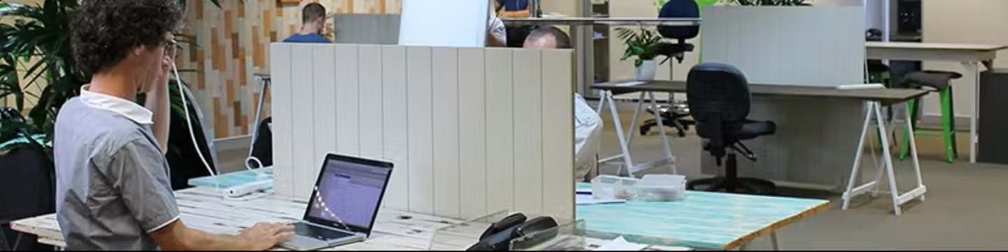 Male sits at a laptop in an office environment